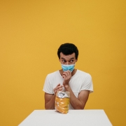 man holding face mask about to eat chips