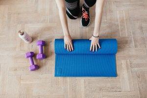woman rolling up exercise mate