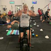 woman making peace sign while on exercise bicycle