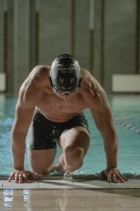 man in swimming cap getting out of the pool