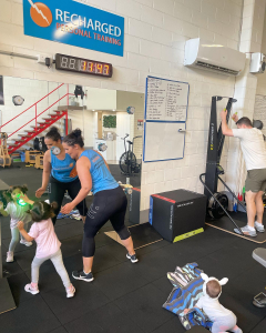 mother and child in a gym exercising in front of a mirror