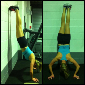 woman doing push up handstands against a wall