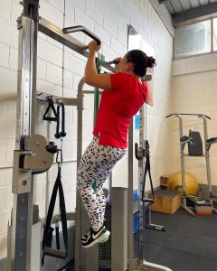 woman in red shirt doing pull ups