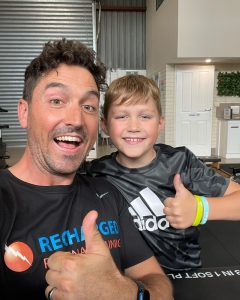 a man and his son doing a thumbs up in active wear
