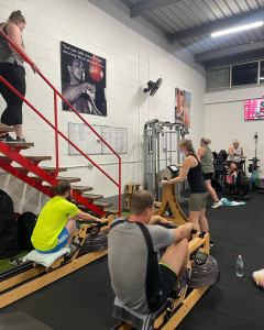 people in a studio working out on weights and rowing machines