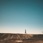 man running on wall with blue sky