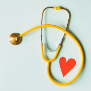 stethoscope wrapped around a red paper heart