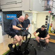 two men working out with a personal trainer supervisor