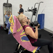 woman lying on bench about to push wights above her head