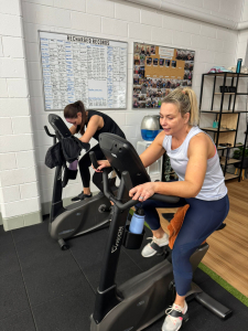 two women on the exercise bikes at a small gym