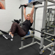woman with arms up doing hanging abs crunch exercise.