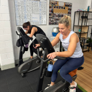 two women on exercise bikes at a gym
