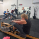 older woman using rowing machine in personal training gym