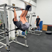 man doing feet to bar pull up