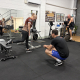 personal trainer crouched next to woman lunging with hand weights